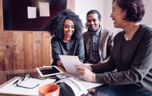 people going smiling while looking at paper